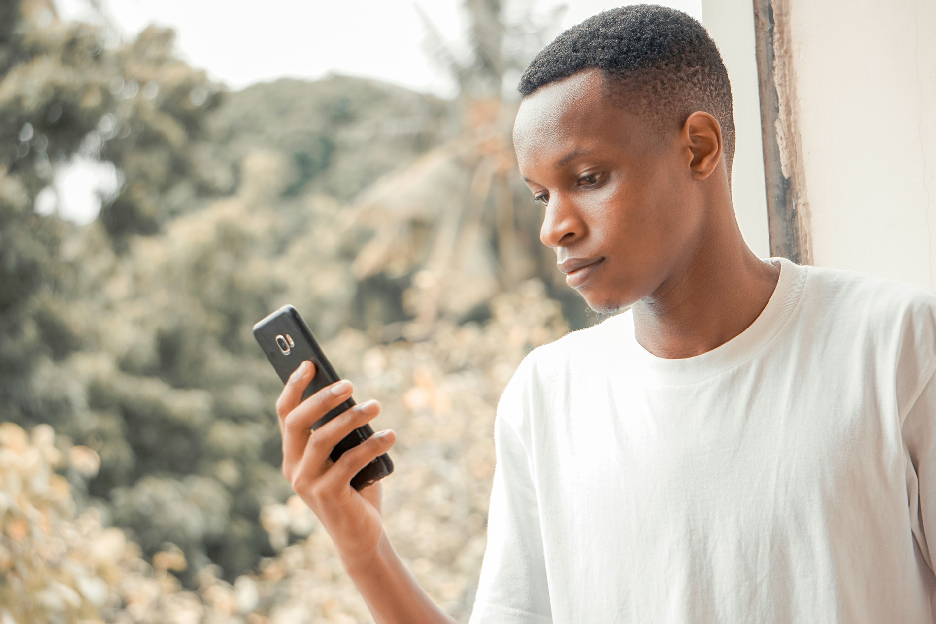 Young man checking his Kivo investment on his phone